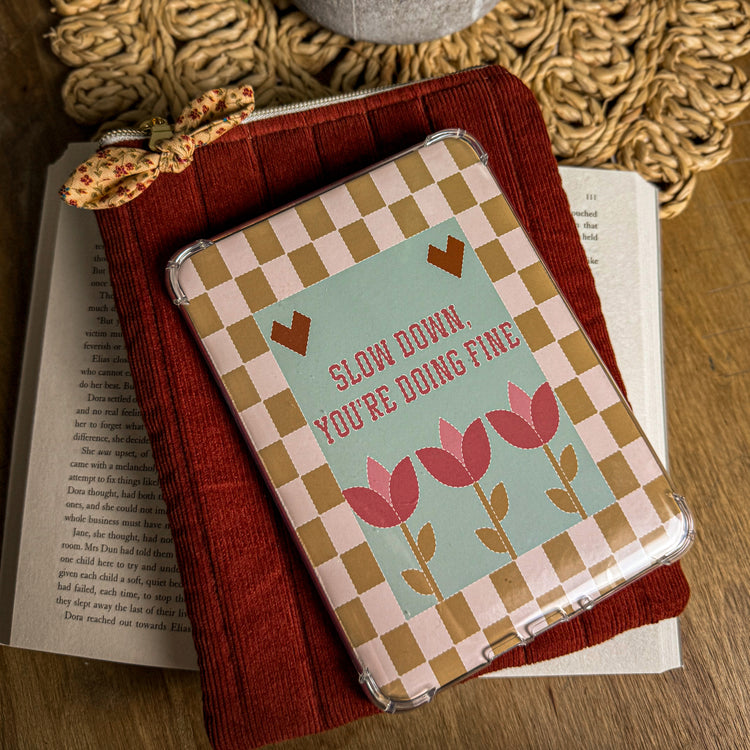 Burgundy corduroy kindle sleeve with a kindle resting atop it