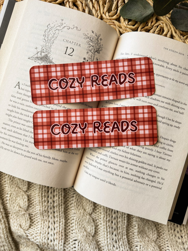Two maroon and white checkered bookmarks with 'Cozy Reads' text on an open book.