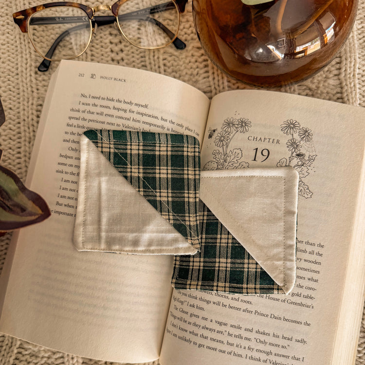 Set of 2 Cream and green plaid fabric corner bookmarks, flat lay on a cozy blanket