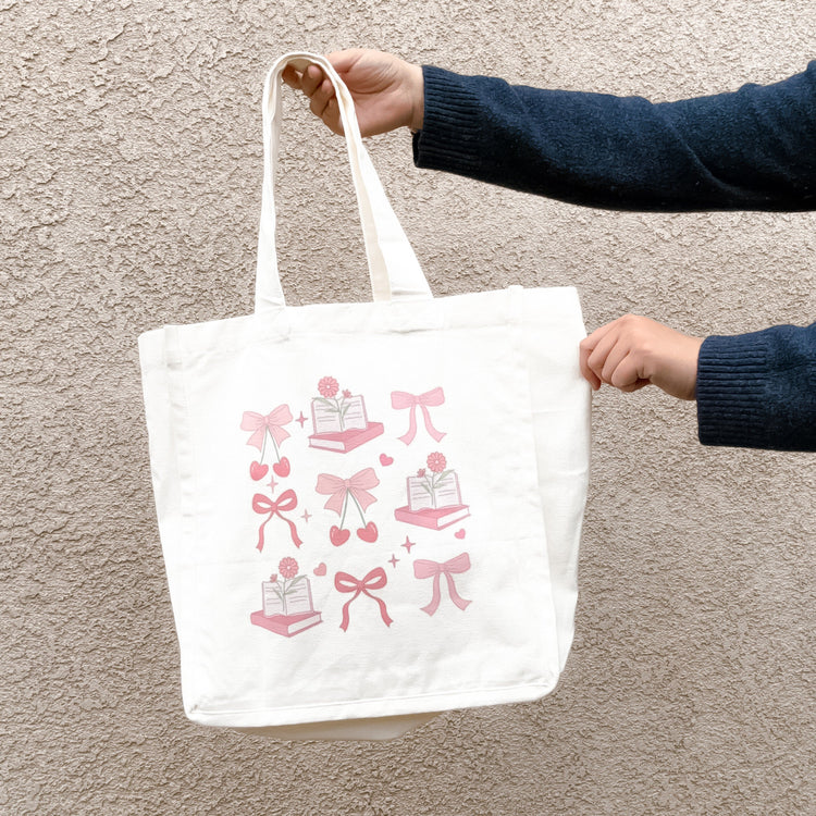 Close-up of coquette aesthetic tote bag with bow and book illustration