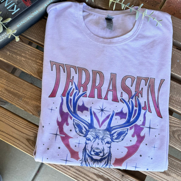 Throne of Glass Terrasen graphic tee styled with fantasy books and cozy reading props.