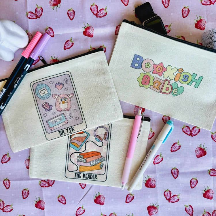 Close-up of tarot card pouch with reader illustration and book imagery