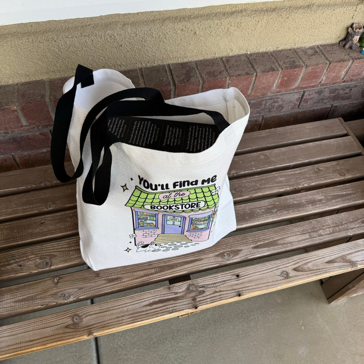 You'll Find Me at the Bookstore canvas tote hanging with long handles visible