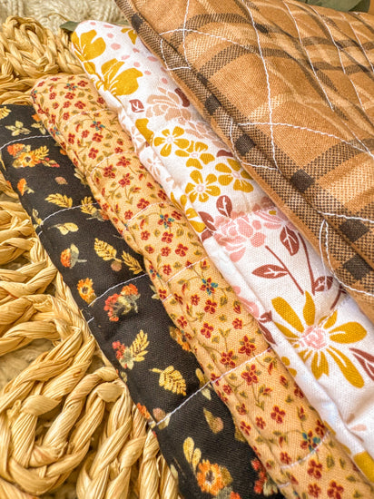 Collection of fabric strips with autumnal patterns on a textured surface