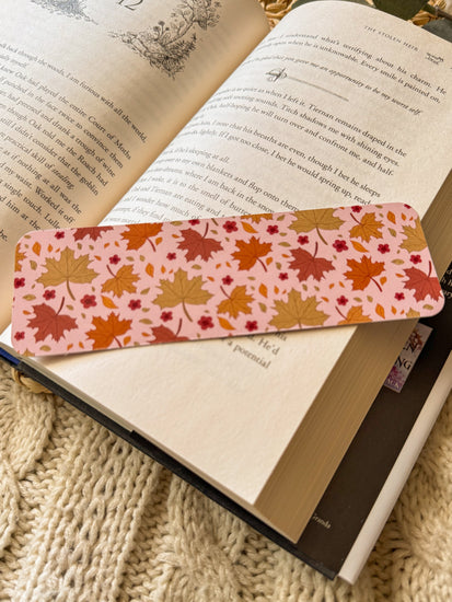 Book with a colorful leaf-patterned bookmark on a textured surface