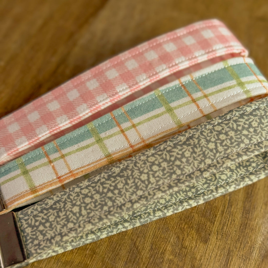 Three fabric straps with different patterns on a wooden surface