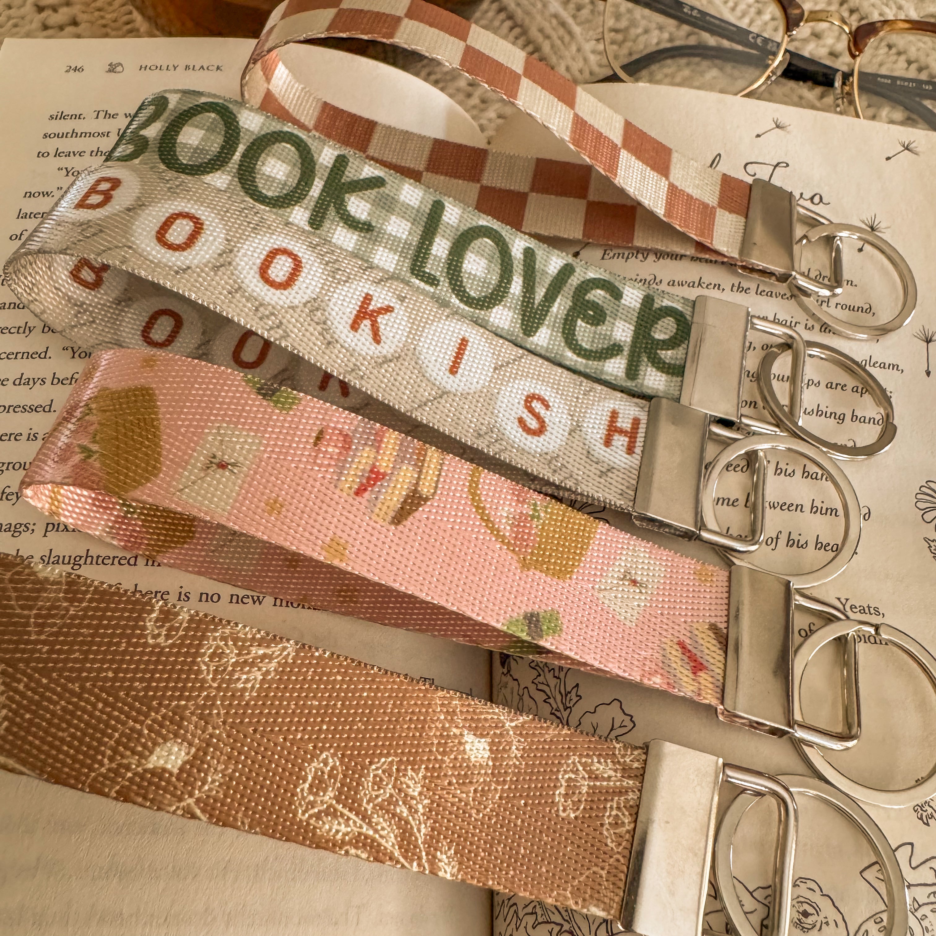 Close up of 5 Bookish Key Fobs on a book