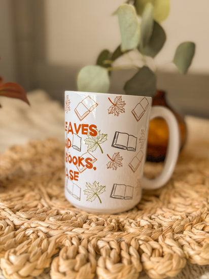 White mug with text and icons on a woven mat with plants in the background
