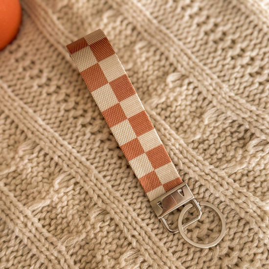 Close up of Neutral Brown Checkered Key Fob with silver metal detailing