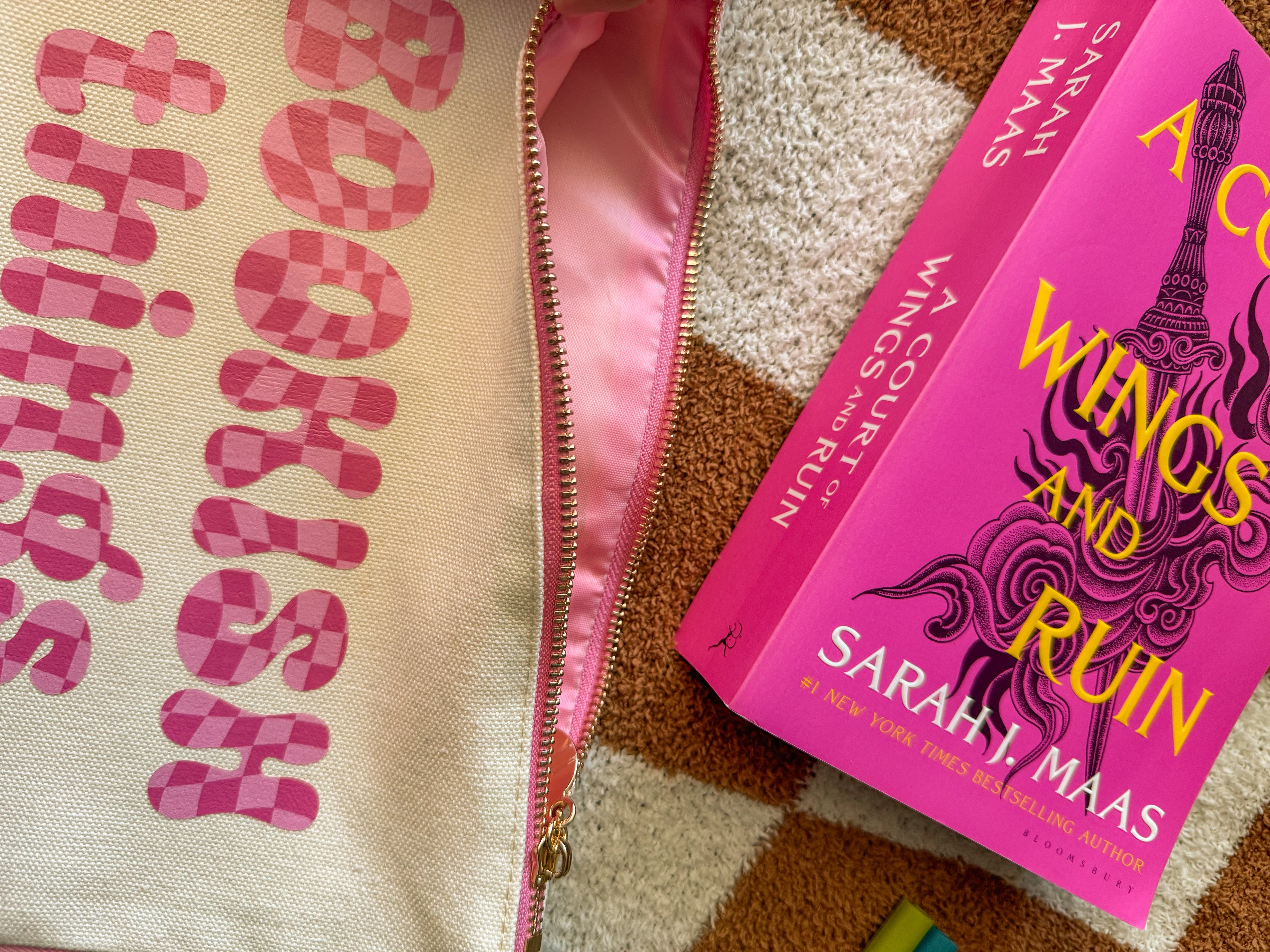 Close-up of pink bubble font on pouch reading “Bookish Things”