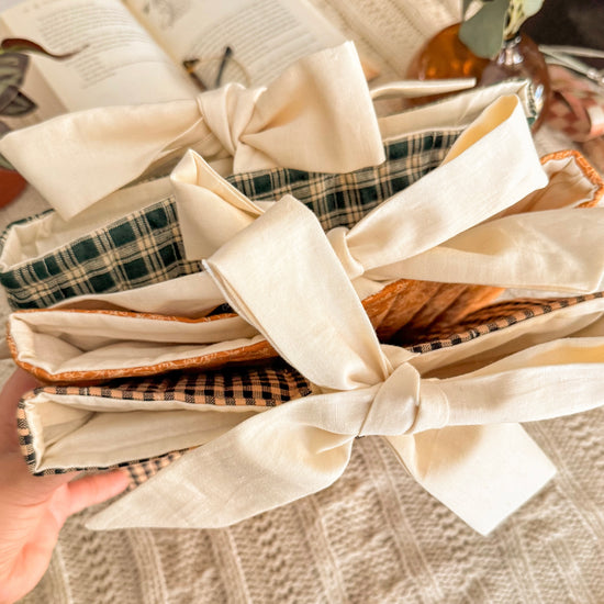 Stack of three fabric book sleeves tied with cream cotton bows