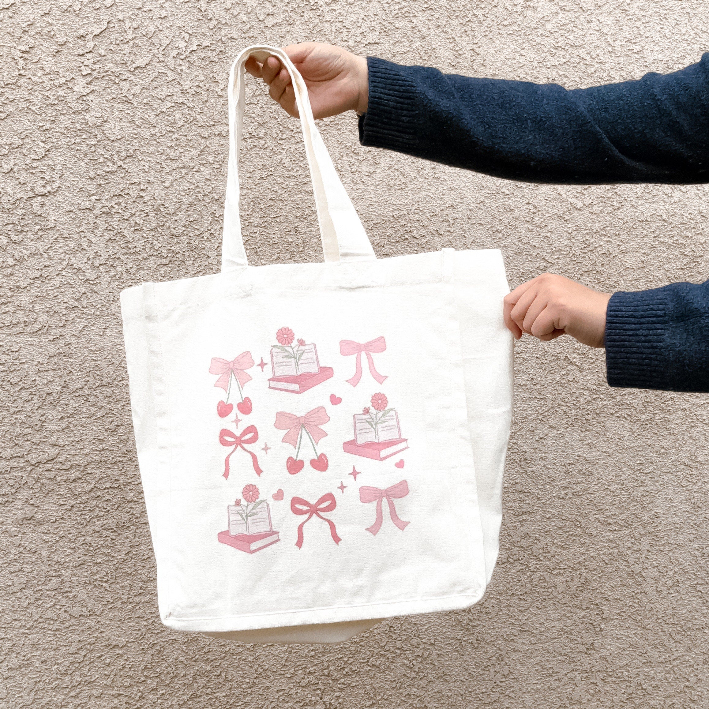 Close-up of coquette aesthetic tote bag with bow and book illustration