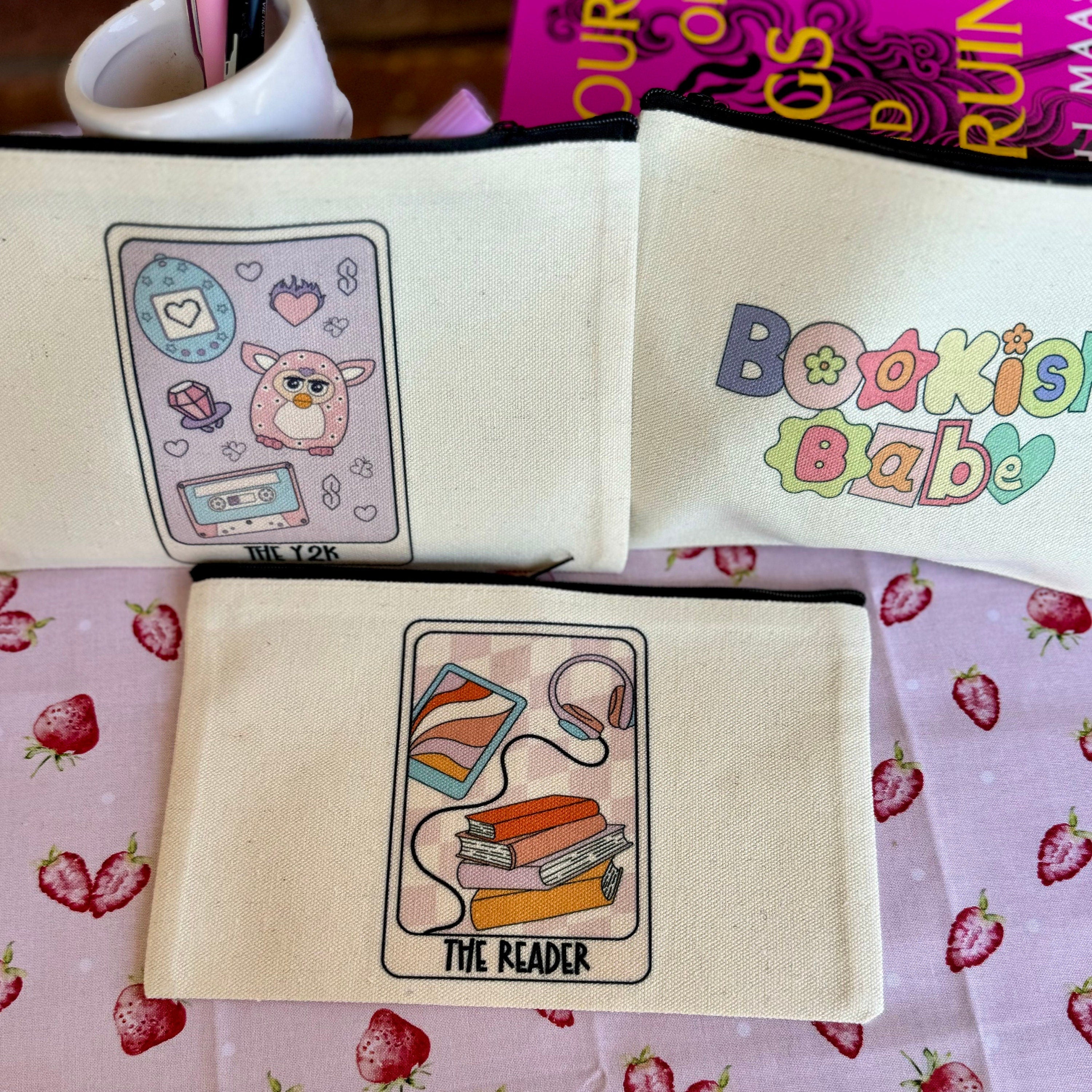 Close-up of tarot card pouch with reader illustration and book imagery