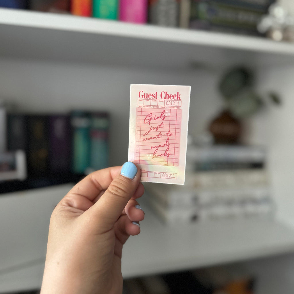 “Girls Just Want to Read” sticker displayed in cozy book nook with blurred background