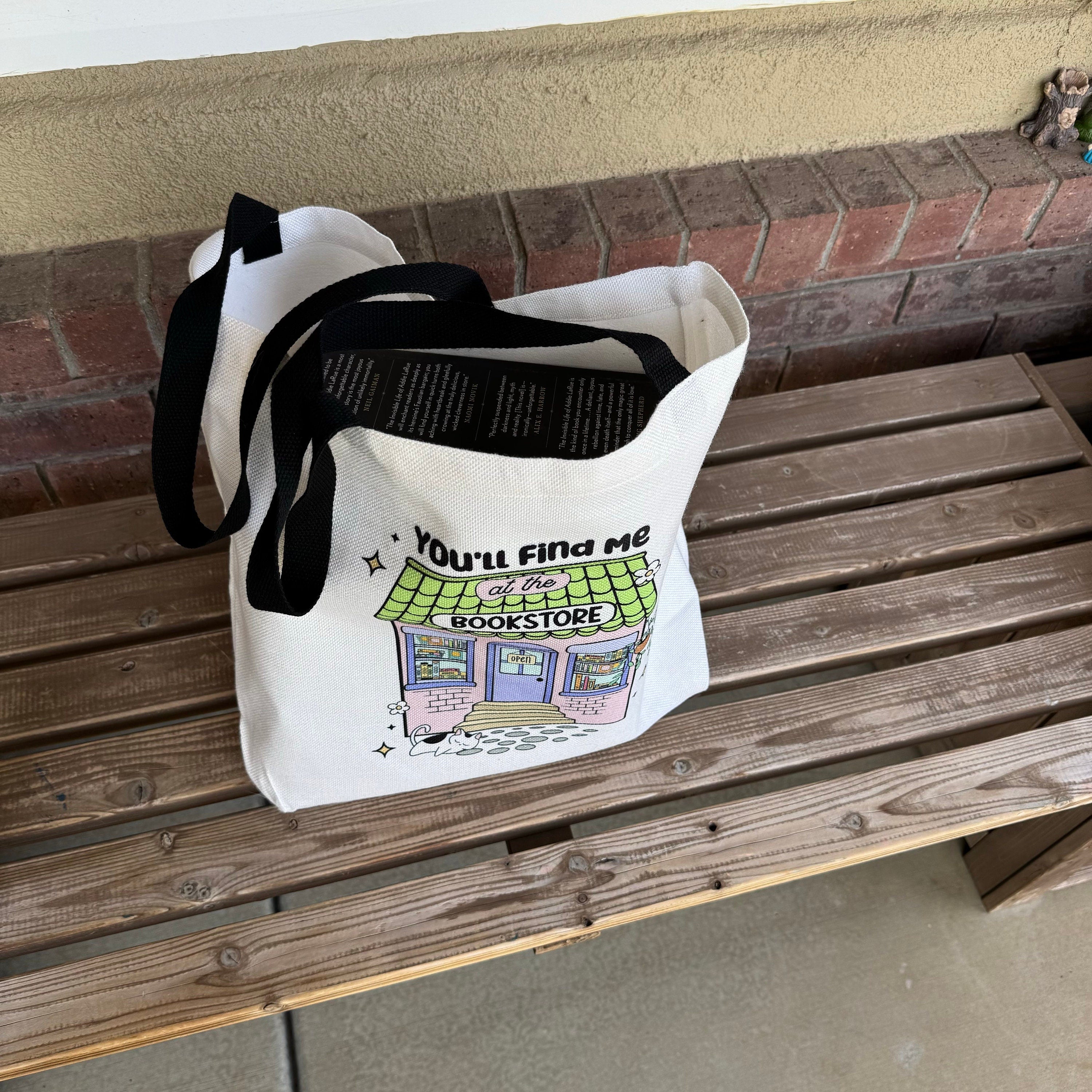 You'll Find Me at the Bookstore canvas tote hanging with long handles visible
