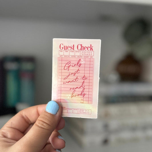 Close-up of single guest check sticker held in front of bookshelf
