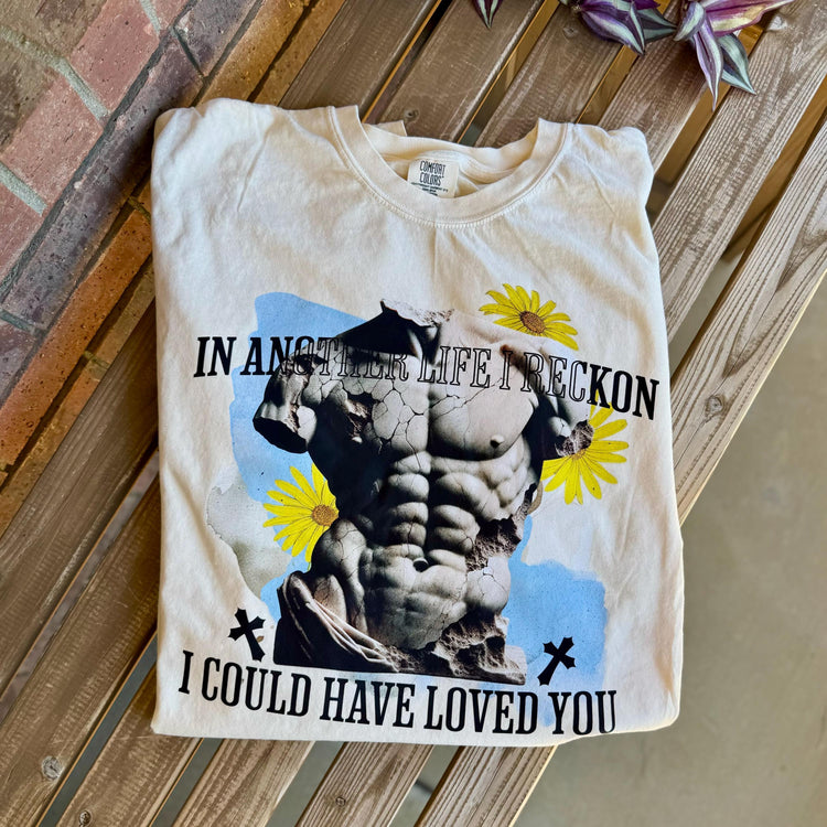 Beige Julian Haites Magnolia Parks quote tee styled with books and cozy accents.