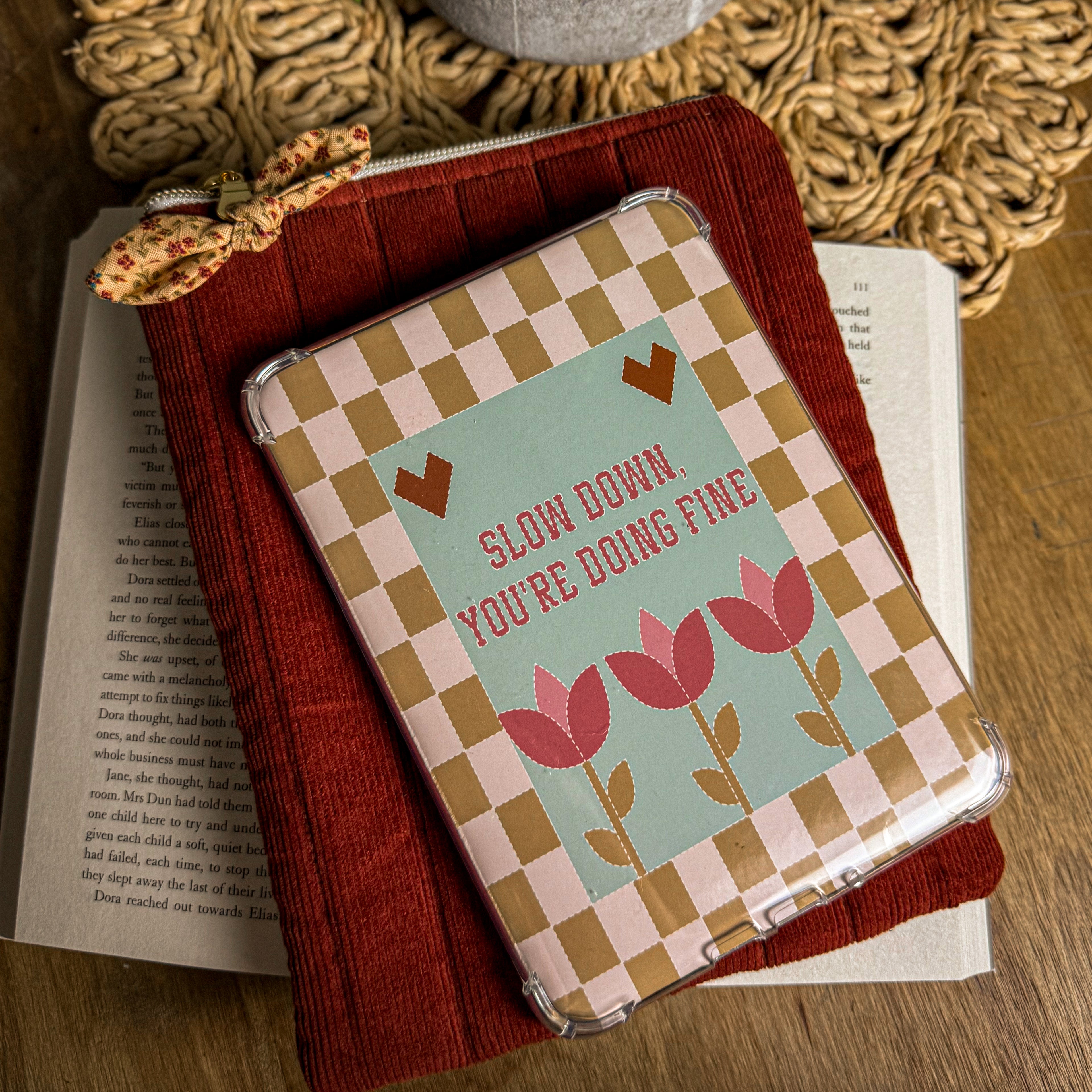 Red corduroy quilted Kindle sleeve with zipper closure, shown with a Kindle e-reader on an open book for a cozy reading aesthetic